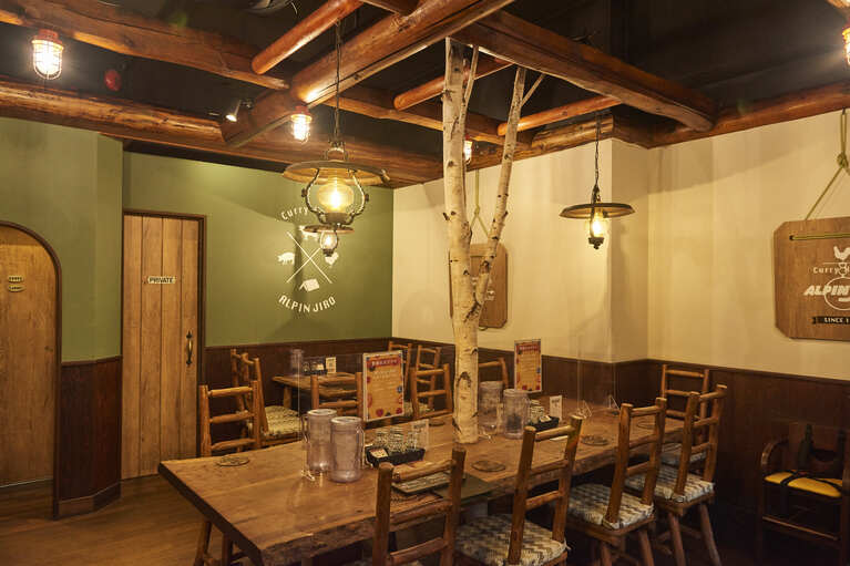 アルペンジローカリーのルーツは尾瀬のスキー場の宿泊ロッジ。その世界観を継承し、店内は山小屋をイメージした木のぬくもりを感じるデザイン。カリーはスキレットで、炊き立てごはんは飯盒のままで提供される。