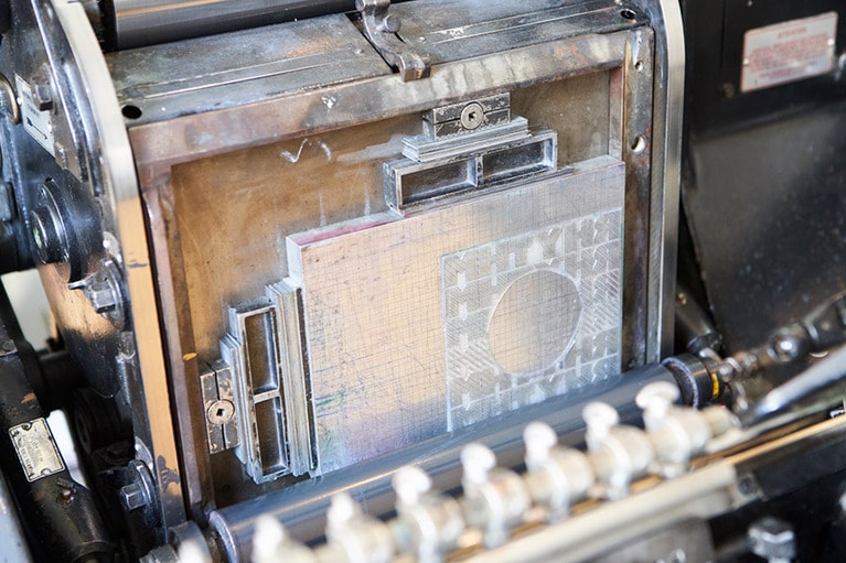 鉛板で作られた版下にインクをのせ、プレスして印刷していく。
