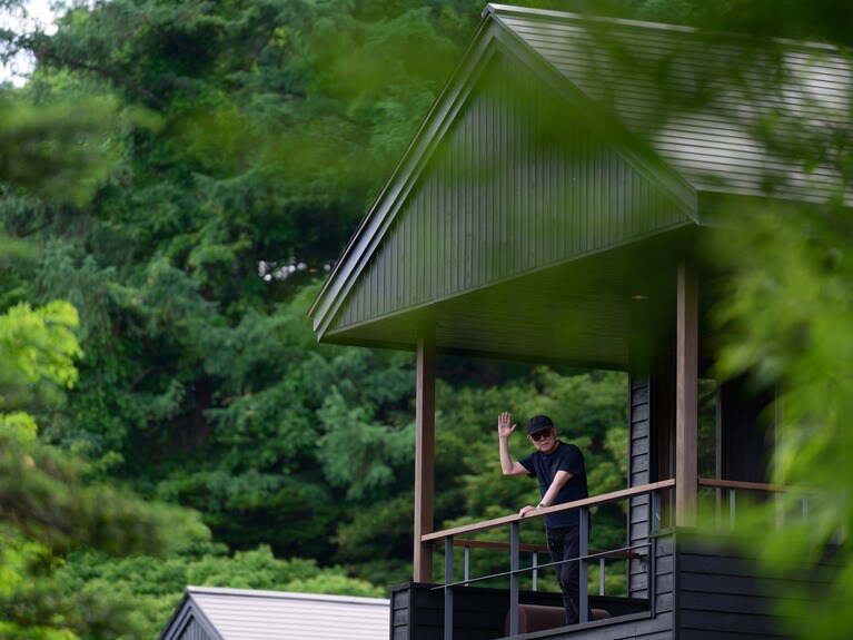 客室のテラスから手を振る松本さん。