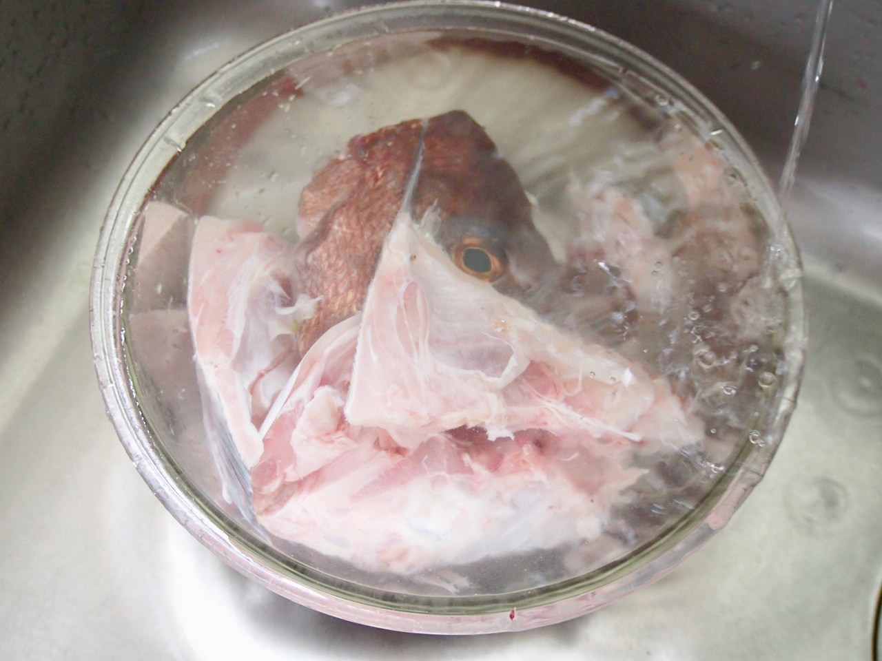 ボウルにアラを入れ、流水で洗う。