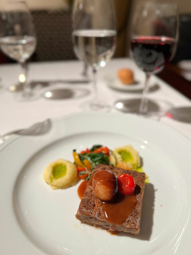 この日のコースのメイン料理はビーフソテー。小さな玉ネギとミニトマトが載っている。付け合わせはセロリ入りポテトクリーム、ほうれん草に似た青菜のソテー。