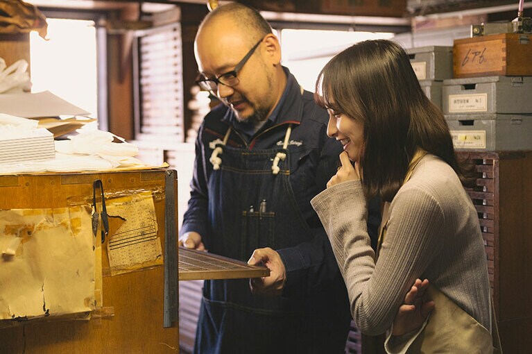 金属活字の説明をする佐々木さんと影山さん。