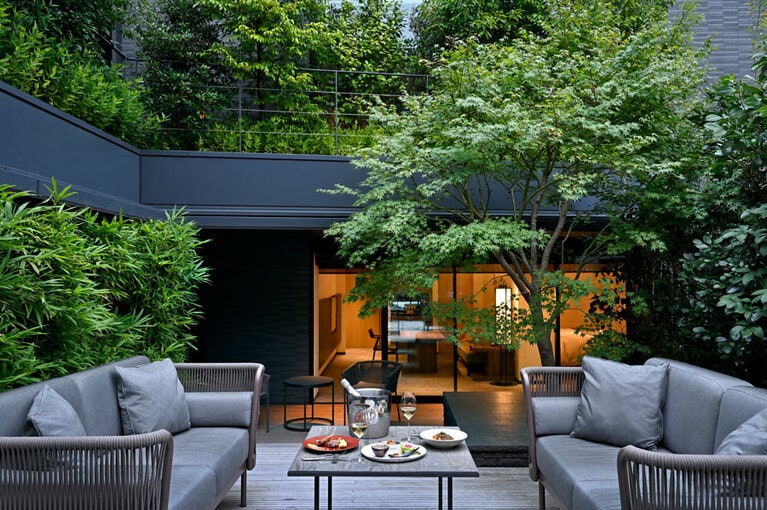 周囲の喧噪が嘘のような空間 “ガーデンスイート” のテラス。ルームサービスの美味を並べて、シャンパンで「乾杯！」。