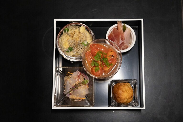 中央)「芸北トマトのフランボワーズマリネ」。以下、右上から時計回りで、「広島野菜のピクルスと生ハム」、「クリームチーズと狩留家ナスジャムのグジェール」、「瀬戸内真鯛の昆布締め」、「音戸ちりめんと野菜のペペロンチーノ」。