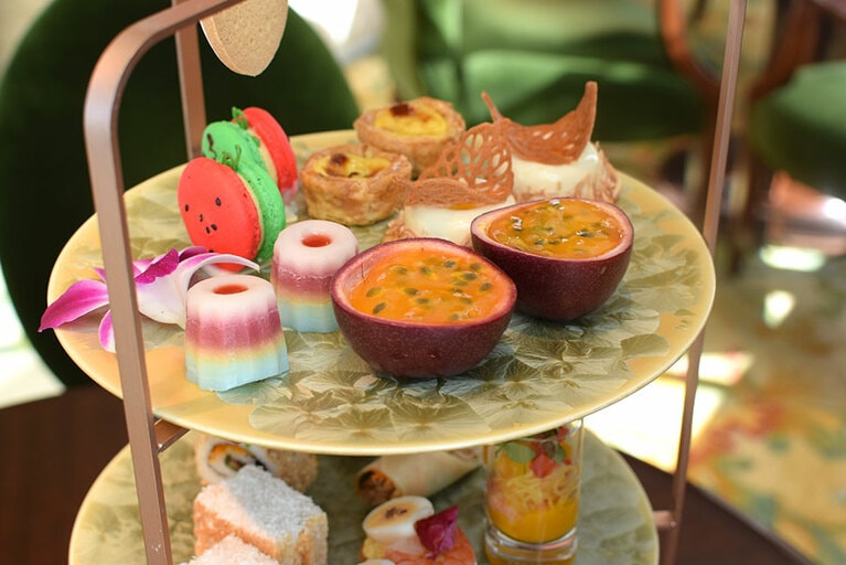 1段目はスイーツ。赤と緑のマカロンは、東京の夏を彩るスイカをイメージ。右に香港のエッグタルト、タイのココナッツムースが並ぶ。