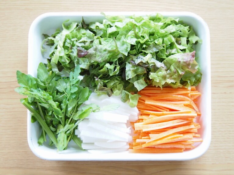 大根、人参は皮を剥いて千切りに。クレソンは大根などと長さを揃えて切る。サニーレタスは1cm幅のざく切りにする。