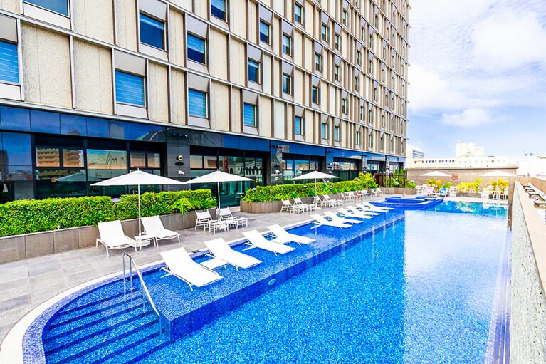 那覇の空が頭上に広がる、リゾート感たっぷりのアウトドアプール。🄫 Hiro Matsui