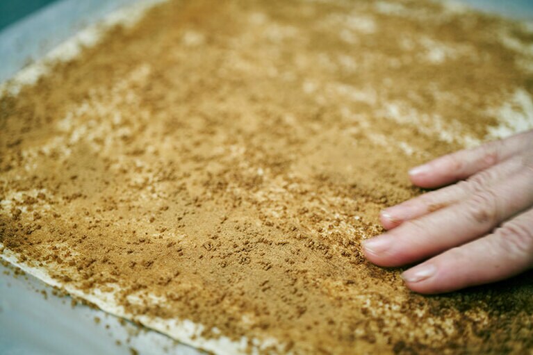 如意クッキーの生地にシナモンパウダーと三温糖をまぜたものを均等にまぶす。