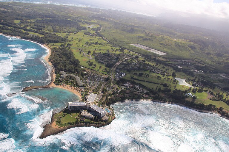オアフ島最北端のリゾートホテルの上空から島を望むと平坦な土地が広がっている。