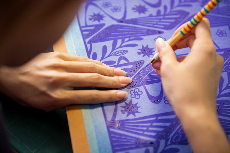 丹念に突き彫りの手法で型紙に模様を描く「型彫り」の工程。