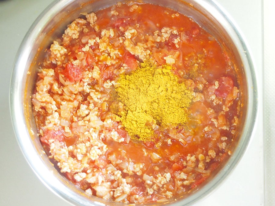 (5) トマト缶、カレー粉を入れ、食材がひたる程度の水を入れて煮込みます。