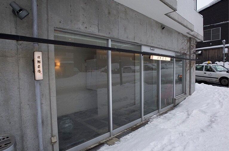 「握 群来膳」はビルの1階。ガラス戸を開けた中のもうひとつの戸を開くとカウンターがある。