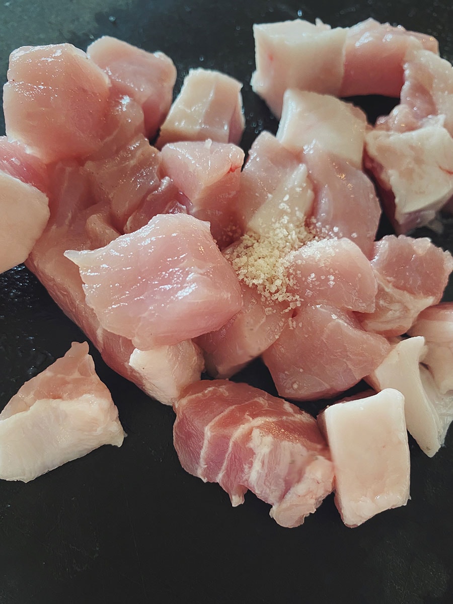 【ごろっと豚肉とマッシュルームのパセリバター炊き込みごはん】(3) 豚肉はマッシュルームと同じくらいの大きさに食べやすく切り、塩ひとつまみで下味をつけておく。