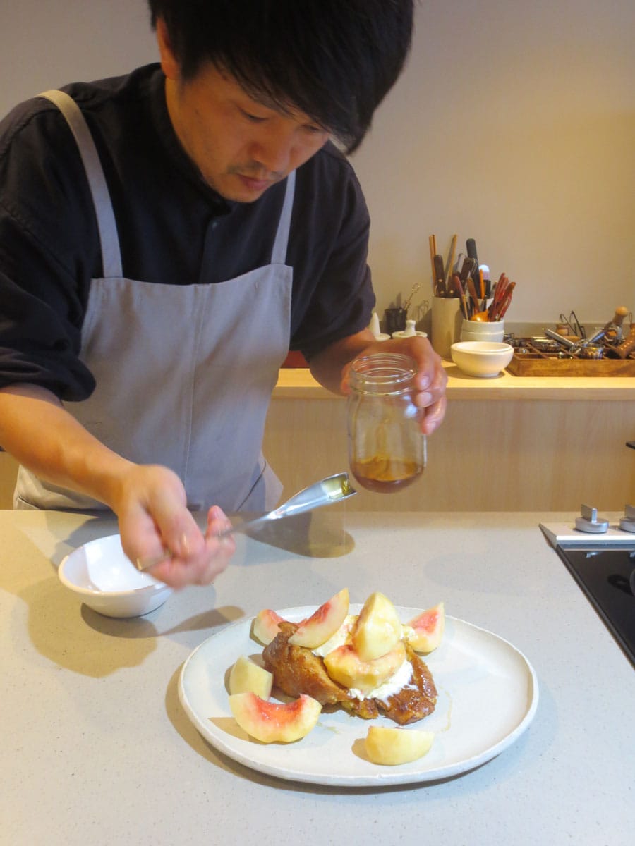 フレンチトーストの仕上げに日本ミツバチの蜂蜜をかける伊藤さん。