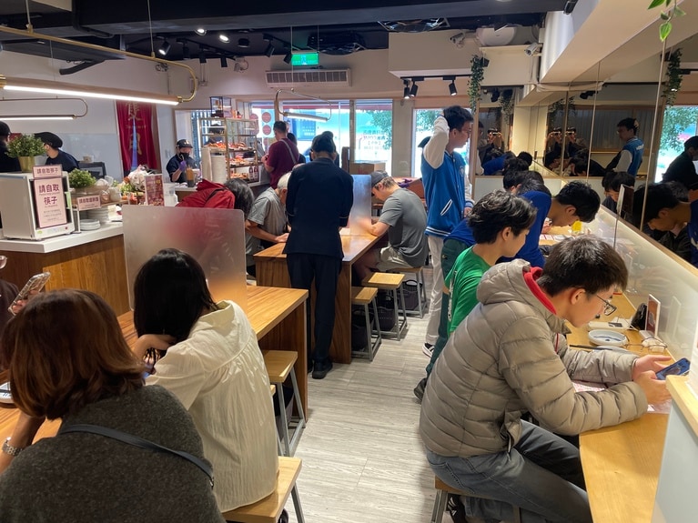 開店直後からこの賑わい。木目を基調とした店内は清潔感があります。