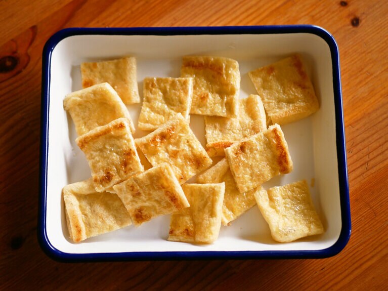 両面焼いてほどよくカリッとなったら、熱さに気をつけつつ、それぞれ8等分に切ります。ひと口大、2～3センチ角のイメージ。