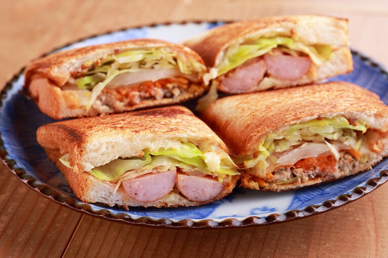 【二条小屋】オイルサーディンとキャロットラペ、ソーセージのホットサンド 390円(税込)。