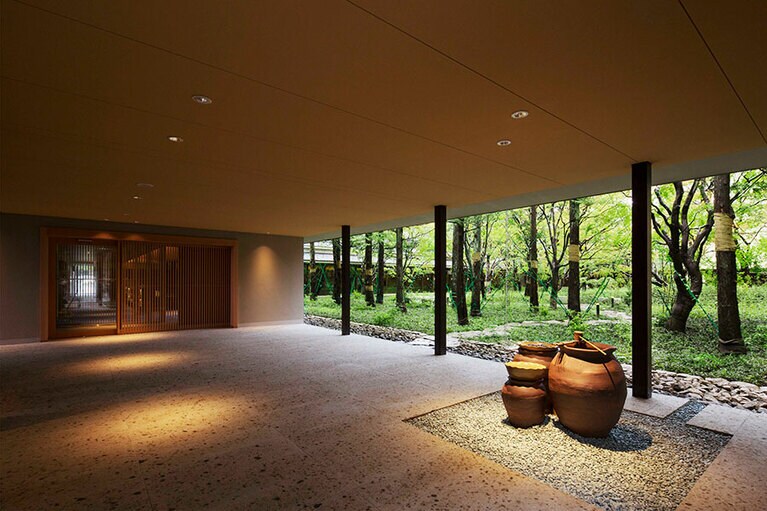 屋外とシームレスなエントランスには益子焼の水琴窟。