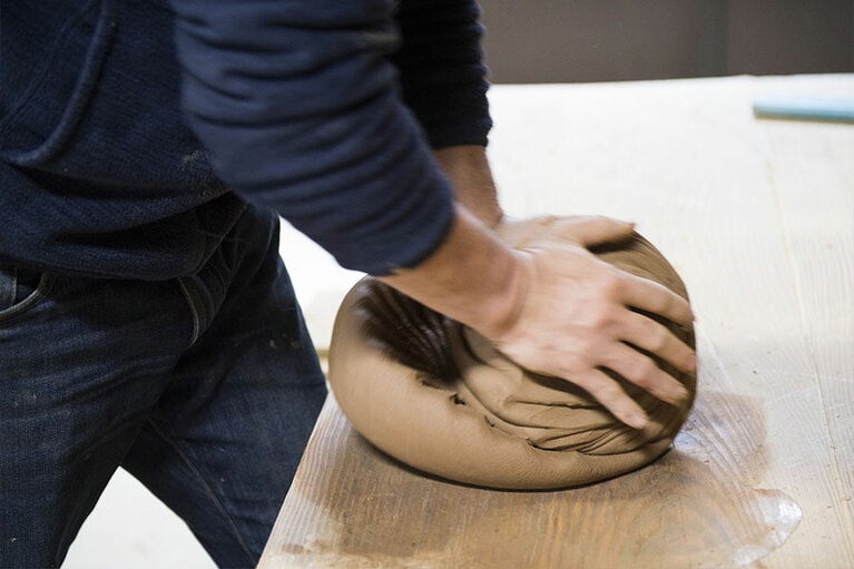 「子どもの頃、学校の敷地内に登り窯があって、美術の先生と一緒に焼き物を楽しんでいたんですよ」。穏やかな口調とはうらはらに、土を打つ姿が力強い。