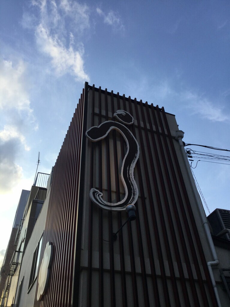 青空に登りそうな「う」が目印のビル。