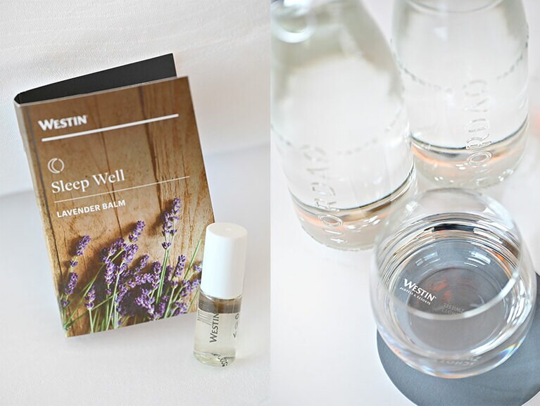 客室には、まるで雲の上のような寝心地の “ヘブンリーベッド” のほかに、さまざまなウ ェルネスアイテムが。 写真左：オリジナルのラベンダーバームは、穏やかな眠りのお供に。 写真右：リサイクルガラスボトルを用いた北欧生まれのサステイナブルなプレミアムウォーター “NORDAQ” も全客室に。