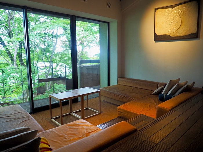 寝転べるほどに大きなソファがある客室。和紙や漆、真鍮、古材、陶板など、日本古来の材を用いた落ち着いた空間が、那須の自然とうまくマッチする。