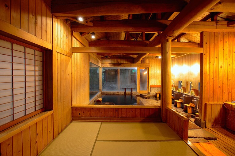 柱や梁に巨木を配した重厚な内湯。脱衣所も畳敷きで、大名風呂を思わせる造り。