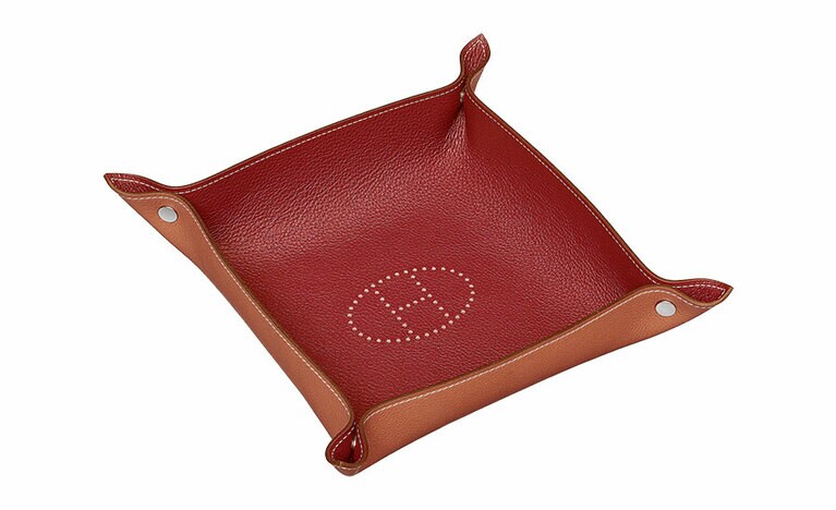 両端のスナップボタンは、真鍮素材。ヴィド・ポッシュ「ミーズ・エ・ルランス・デスク」(H25cm×W25cm)71,000円／エルメス(エルメスジャポン)