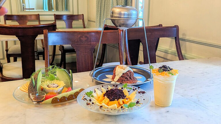 奥中央から時計回りに、レモン香る爽やかな「ショコラ夫人のひまわり畑モンブラン」、濃厚マンゴーな「ひまわりラッシー」、自家製パンナコッタが隠れる「向日葵パフェ」、ビタミンたっぷりの「サンフラワープレート」。