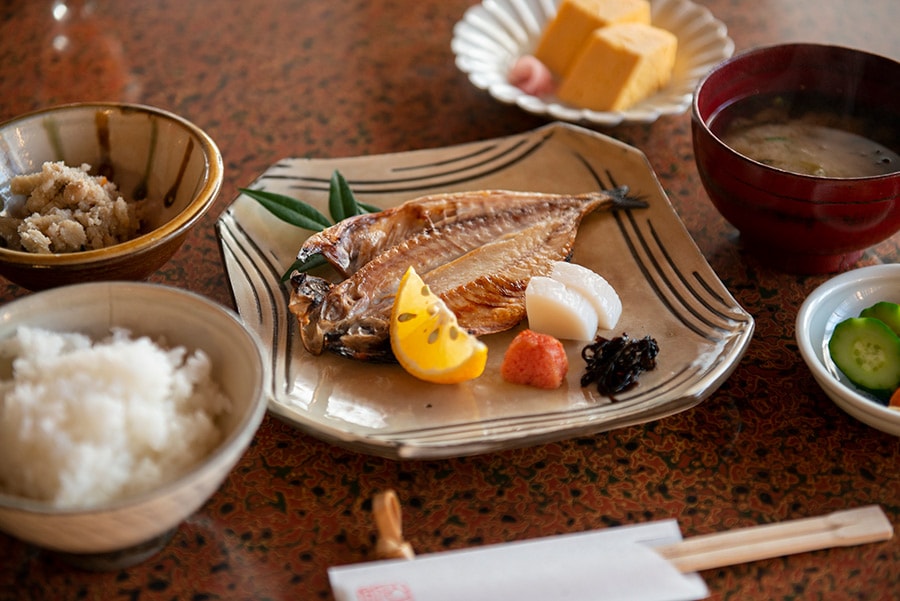 焼き魚と玉子焼きが並ぶシンプルな朝食。器は小鹿田(おんた)焼。