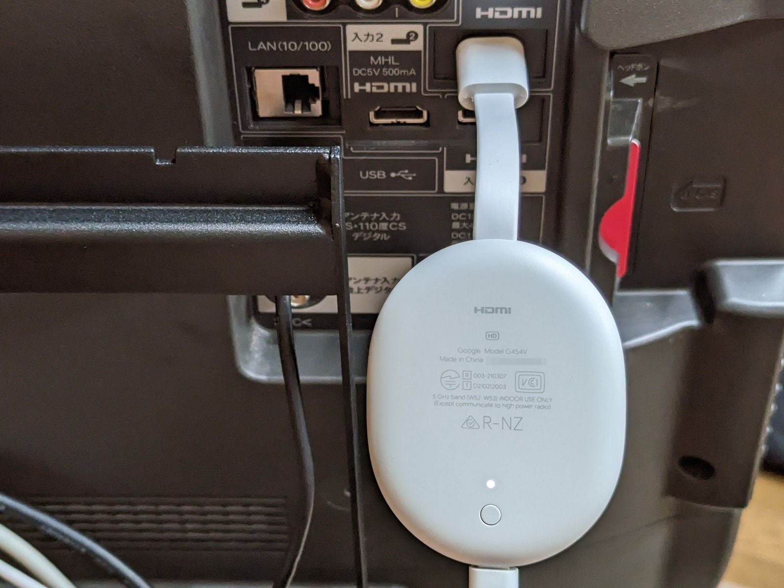 「Chromecast with Google TV」をテレビ背面のHDMIポートに接続した様子。取り回しはよいのですが白いボディはテレビとの組み合わせではやや目立つかも？