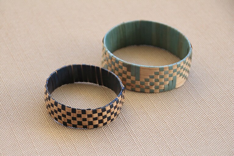 手前の市松模様のブレスレットが私の作品。織り方を変えると後ろのような柄にもできる。