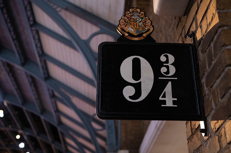 ホグワーツのロゴと9と3/4番線のホームの案内板。