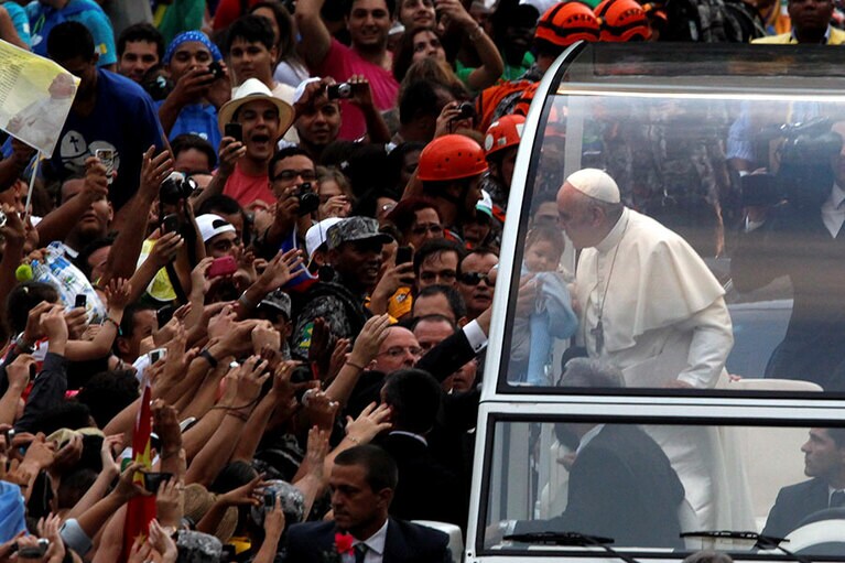 バチカンから持ち込まれた両脇が空いたオープン・カー。熱狂の渦に囲まれ途中、数度止まるも無事に終了。©ZUMA Press/amanaimages