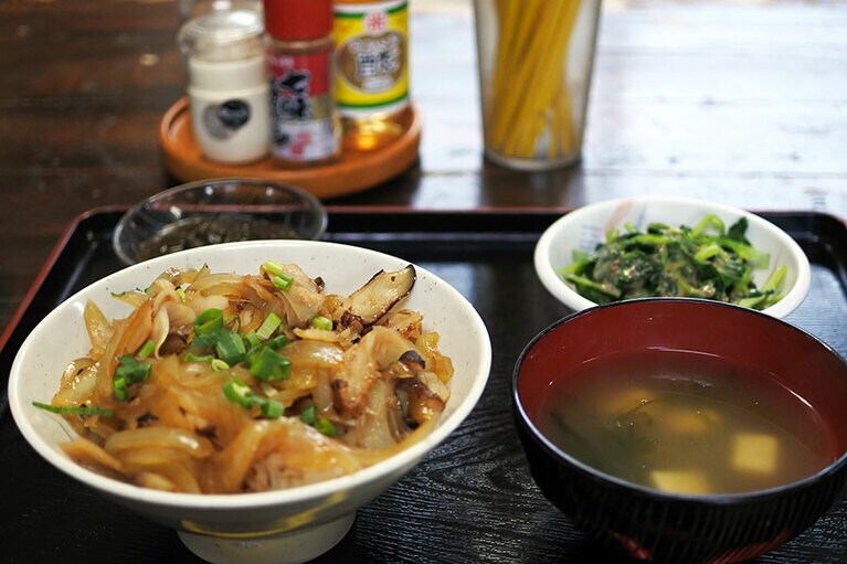 たこの燻製と甘辛く似た玉ねぎをのせた、カーキだこ丼。おぷゆう食堂は民宿もやっています。