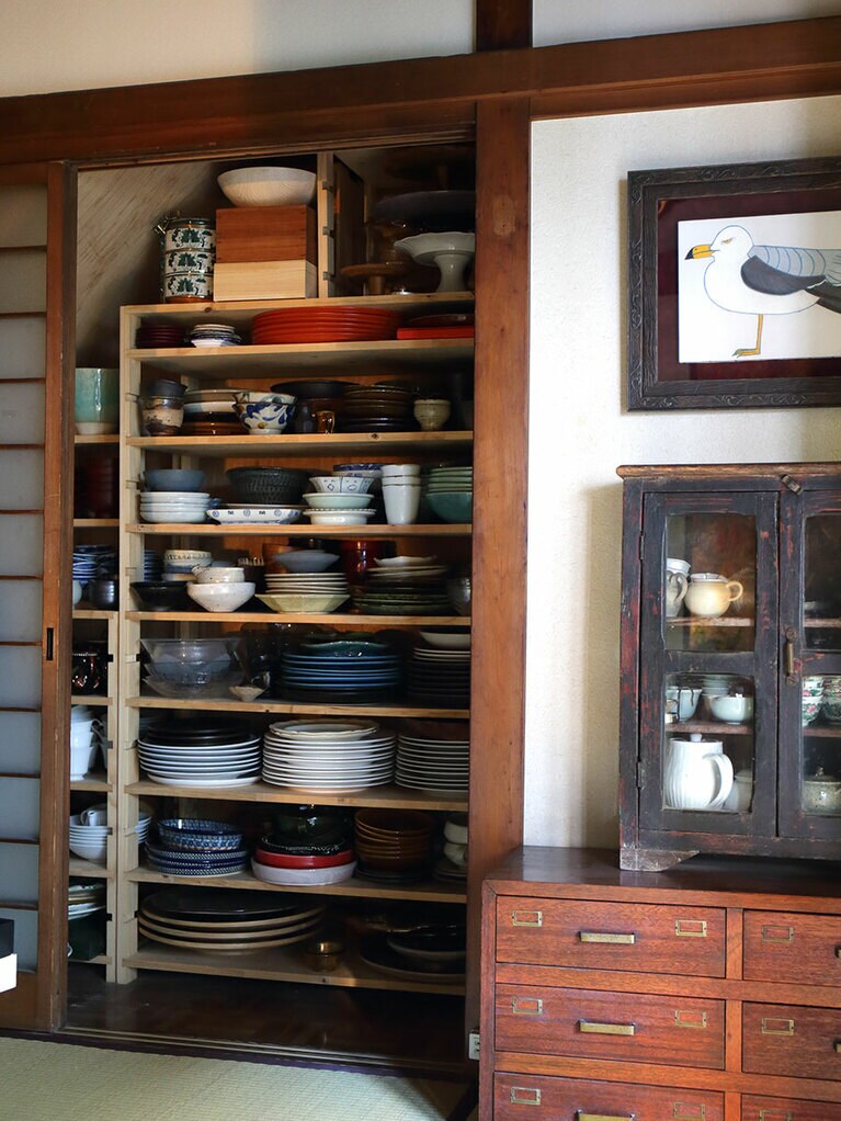 台所に続く和室をダイニングに。ここの障子を開ければ、手作りの棚が。麻奈さんが海外で集めたり、蚤の市で選んだりした器類がずらり。右の小さな棚には、お茶の道具を。紅茶、日本茶、中国茶用と幅広く集めている。