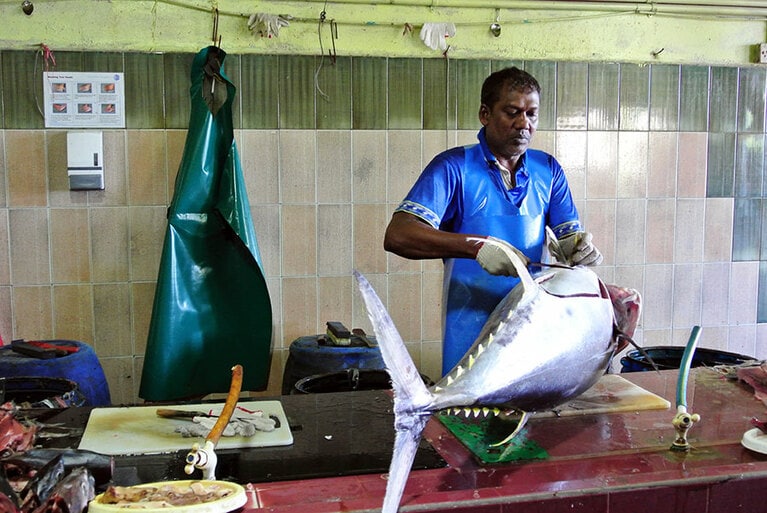 マグロをさばいている市場の人。ショーではなく、作業です。
