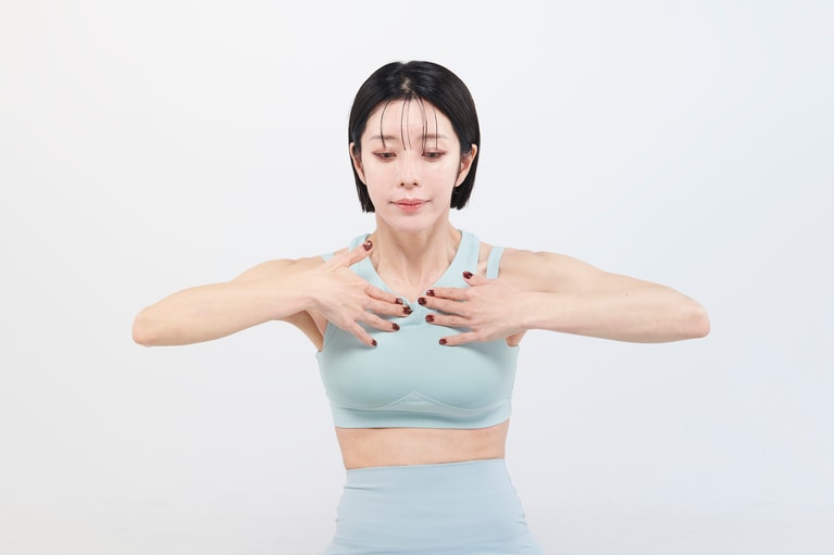 【STEP.2】10秒ほどかけてゆっくり丁寧に息を吐く。鎖骨の付け根にある胸鎖関節を押し込む。肩をすくめない。肋骨の下を突き出さない。腰は丸めない