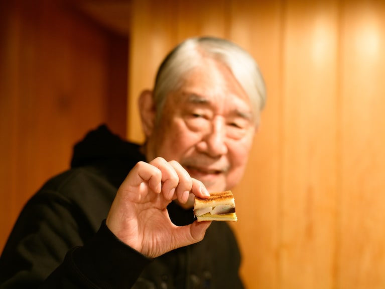 鯖サンドににっこりの松本さん。