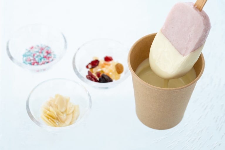 温かいチョコに冷たいアイスバーをくぐらせ、パリパリになる前に急いでトッピングを。