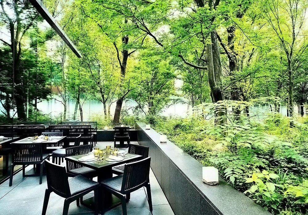 「ザ・カフェ　by アマン」の風が抜けるテラスや、大きな窓越しに緑鮮やかな森を眺めながら、ほどよく冷えた生ビールやビアカクテルで夕涼みを。