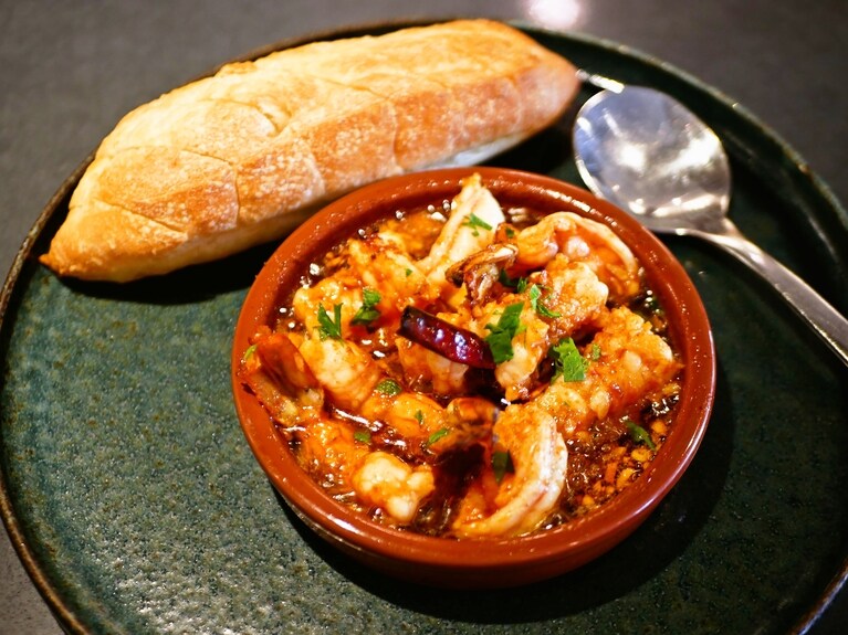 ほどよい辛さの海老アヒージョ（23ドル）は酒泥棒。添えられたバゲットもフカッとして最高においしい。