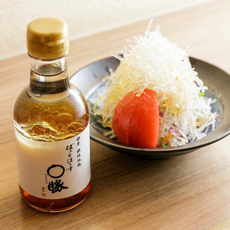 サラダ340円は、大根、海藻、水菜などの組み合わせに、出汁のきいた〇勝オリジナルの醬油ドレッシングがかかる。はっしーさんもリピート買いするドレッシング440円は本店で購入できる。