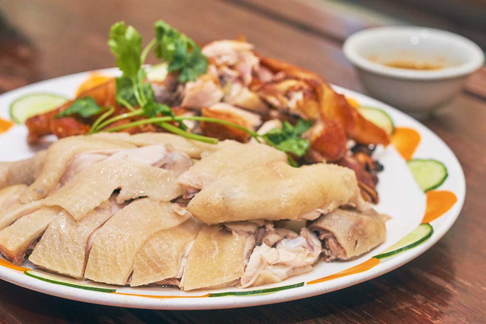 丸茹での鶏をぶつ切りした「海南白切鶏」をタレにつけ、茹でたときに出る油で調味したごはんと共にいただく「文昌鶏」は、四大名物料理の1品。