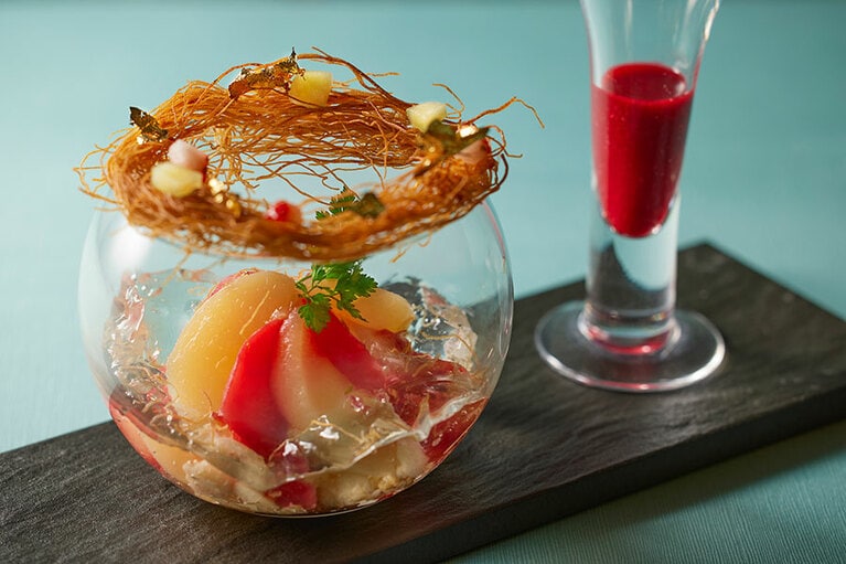 赤ワイン仕立ての桃のコンポートにバニラアイスを合わせ、甘酸っぱいフランボワーズソースをかけて楽しむパフェ「大人のピーチメルバ」2,700円（税・サ込）。