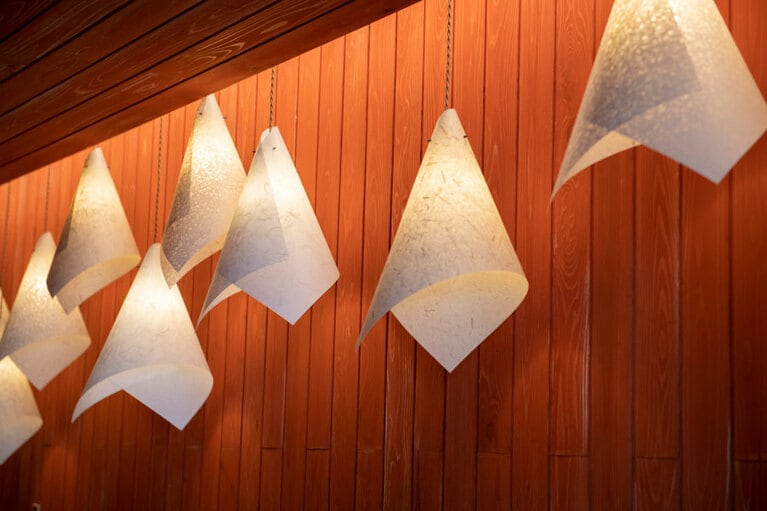 和紙の照明が柿渋色の壁に調和。館内をふんわりと照らす。