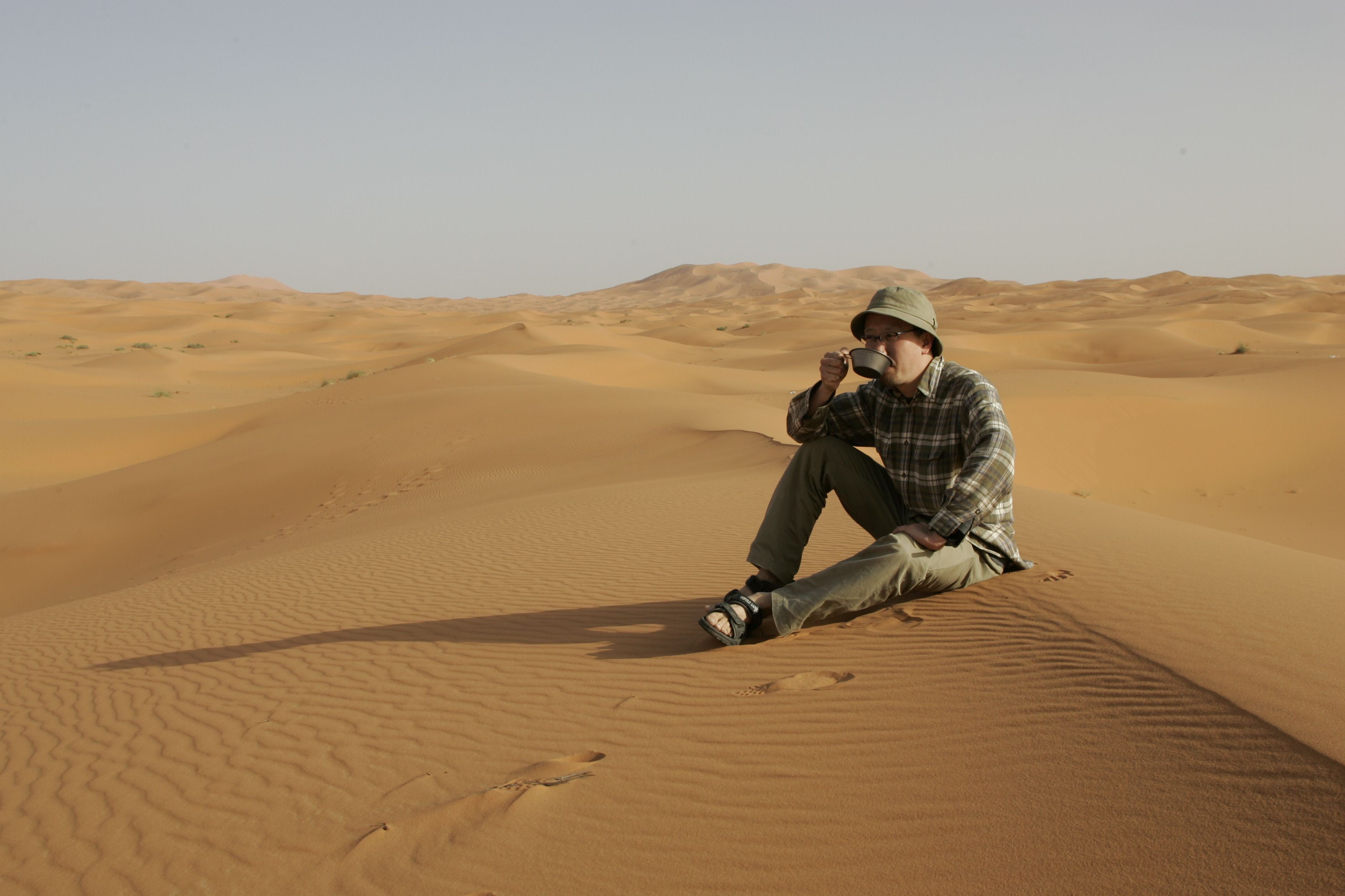 サハラ砂漠のど真ん中で貴重な水を飲む筆者