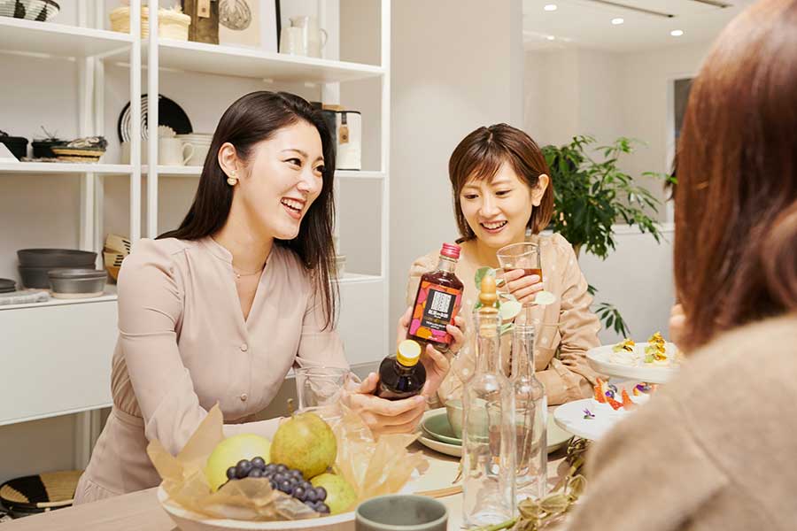 〈ストレート〉と〈アップル〉、二つのフレーバーの飲み比べを楽しむ堤さん(左)と内藤さん(右)。おしゃれなボトルも女性には高評価。