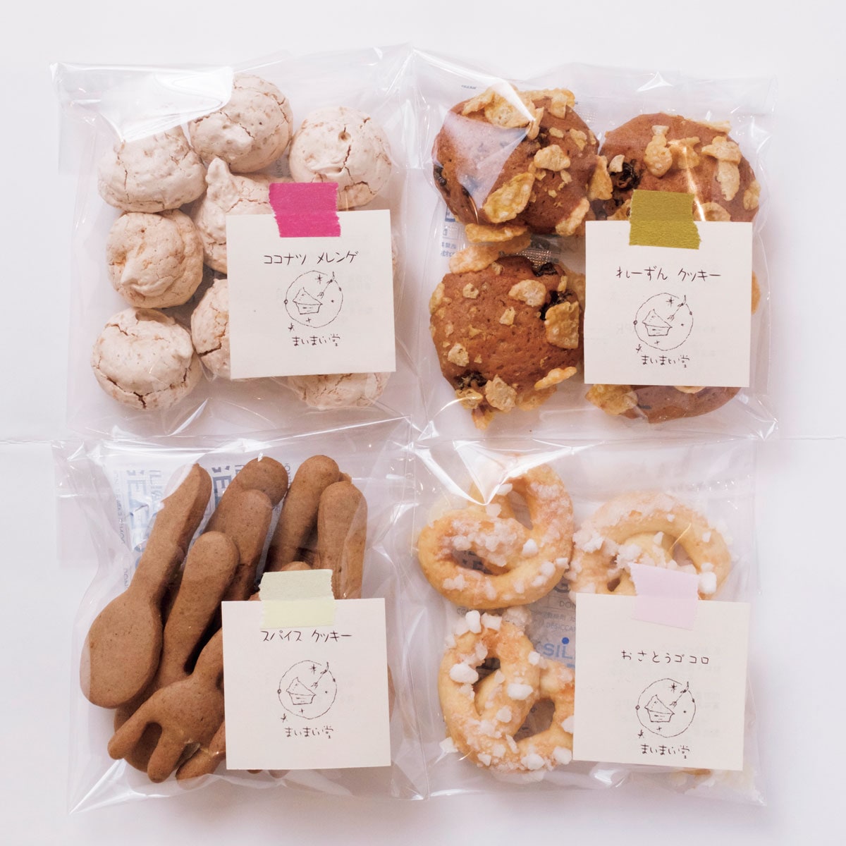 ガラスのショーケースに並ぶ手作りクッキー。「れーずんクッキー」「おさとうゴコロ」「ココナツメレンゲ」「スパイスクッキー」すべて270円(イートインは275円)。