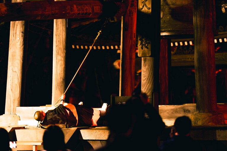 大鐘を撞く様子。寝そべってみえるが、これほどの反動をつけないと音が鳴らないのだという。